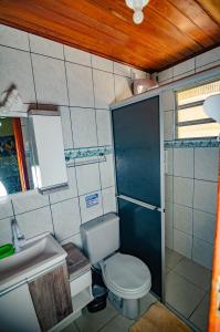 a small bathroom with a toilet and a sink at Pousada Vila da Praia in Pinheira +97 photos