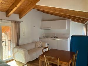 ein Wohnzimmer mit einem Sofa und einem Tisch sowie eine Küche in der Unterkunft Casa Amélie in Caslano
