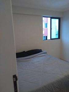 a bedroom with a bed and a window at Completo com Ar-condicionado in Recife