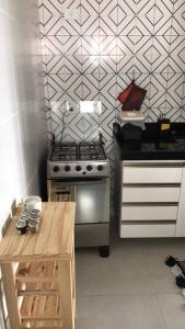 uma cozinha com um fogão e uma mesa em Completo com Ar-condicionado no Recife