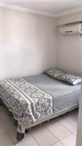 a bed in a white room with a bedskirtspectspectssenalsenalsenalsenal at Completo com Ar-condicionado in Recife