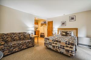 a bedroom with a bed and a couch at Cedarbrook Queen Studio 110 in Killington