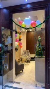 um quarto com uma janela com uma árvore de Natal e balões em Elite Grand City no Cairo