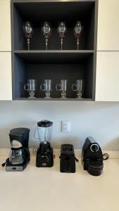a kitchen counter with a blender and wine glasses at Moderno y espacioso departamento en Aldea Zama in Tulum