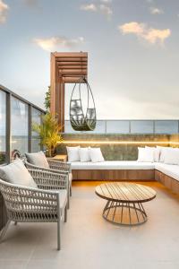 un patio con sofá, sillas y mesa en Way Bossa #C2 - Flat Praia do Bessa by Carpediem, en João Pessoa