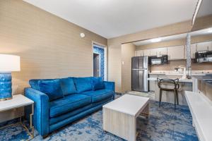 a living room with a blue couch and a kitchen at 3 Palms Tucson North Foothills in Tucson