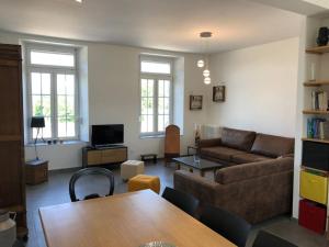 ein Wohnzimmer mit einem Sofa und einem Tisch in der Unterkunft La Brossière in Landouzy-la-Cour