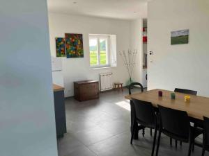 a dining room with a wooden table and chairs at La Brossière in Landouzy-la-Cour