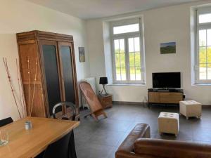 a living room with a couch and a tv at La Brossière in Landouzy-la-Cour