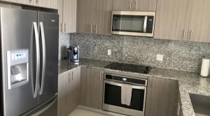 a kitchen with a stainless steel refrigerator and microwave at Doral City View in Miami