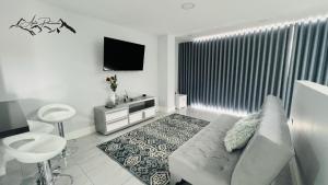 a white living room with a couch and a tv at APTO Panorama in Filandia