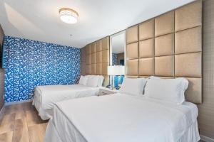two beds in a room with blue and white walls at 3 Palms Tucson North Foothills in Tucson +35 photos