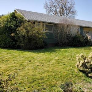 une maison avec une cour herbeuse devant elle dans l'établissement Sweet 2 bedroom close to U of Oregon & track!, à Eugene
