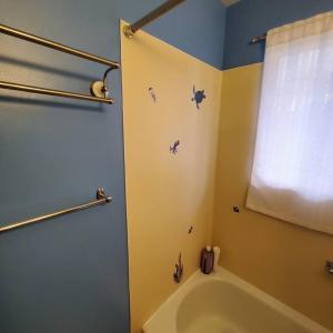a bathroom with a tub and a shower with a window at Sweet 2 bedroom close to U of Oregon & track! in Eugene