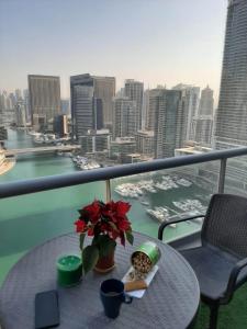 a table on a balcony with a view of a city at ThePenthouse Coliving I in Dubai