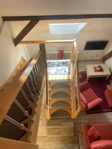 an attic room with a staircase and a living room at Maisonette Wohnung am Hänferdorf in Bühl