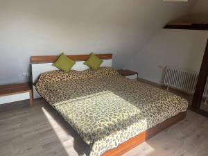 uma cama com duas almofadas verdes num quarto em Maisonette Wohnung am Hänferdorf em Bühl