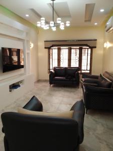 uma sala de estar com sofás e uma televisão de ecrã plano em B8B Chessville Corte 3 em Abuja