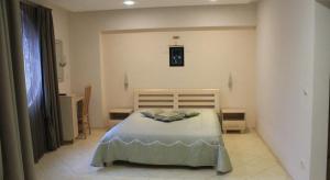 Stela Guest House في تساريفو: غرفة نوم بسرير في غرفة بيضاء