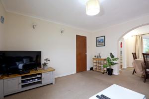 a living room with a flat screen tv on a table at Comfy Quarters from 'TOBS Norwich' in Norwich