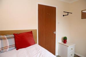 um quarto com uma almofada vermelha numa cama em Comfy Quarters from 'TOBS Norwich' em Norwich