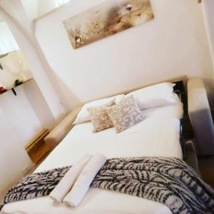 a bed with white sheets and pillows in a room at Suite 800 in Ostuni