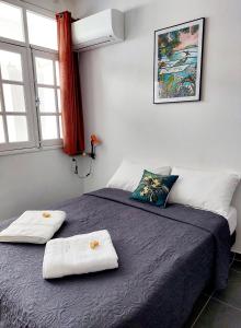 1 dormitorio con 2 camas y toallas. en Perle proche gare maritime et croisières, en Pointe-à-Pitre