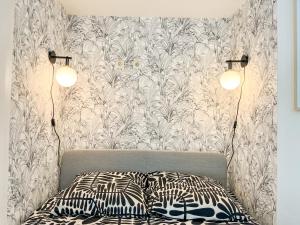 Suite Cumba في فيليوربان: غرفة نوم بها مصباحين وسرير مع وسادتين