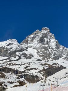 una montagna innevata con una pista sciistica di fronte ad essa di Cervinia a Breuil-Cervinia