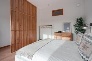 a bedroom with a large bed and a dresser at Modern studio near Metro Station in Senhora da Hora