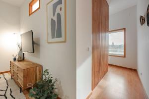 a living room with a television and a wooden cabinet at Modern studio near Metro Station in Senhora da Hora