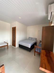 ein Schlafzimmer mit einem Bett und einem Tisch darin in der Unterkunft POUSADA ORTEGA in Bodoquena