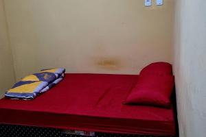 uma cama vermelha com uma almofada em cima em casa com, ar condicionado e suíte no major prates em Montes Claros