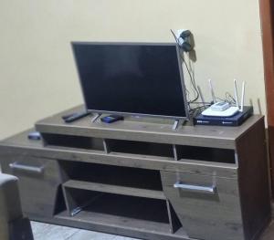 a flat screen tv on top of a entertainment center at casa com, ar condicionado e suíte no major prates in Montes Claros