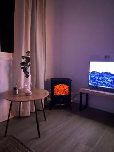 a living room with a table and a tv and a stove at calMar Tenerife 1 in Los Realejos