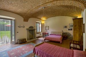 a bedroom with two beds and a fireplace in a room at B&B Cascina Moncrava in Ivrea