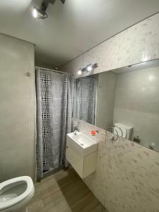 a bathroom with a white toilet and a sink at Cálido Apart en el corazón de Buenos Aires con piscina in Buenos Aires
