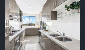 uma cozinha com dois lavatórios e uma grande janela em Resort style 1 or 2 bedroom with pool and free parking em Hornsby