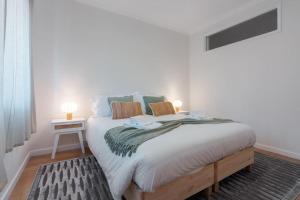 een slaapkamer met een groot bed met 2 lampen erop bij Central 2bed apt in Matosinhos in Matosinhos