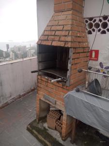an outdoor brick oven with a table on a rooftop at Rocinha House in Rio de Janeiro