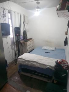 1 dormitorio con 1 cama, vestidor y TV en Rocinha House en Río de Janeiro