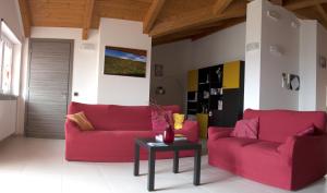 ein Wohnzimmer mit zwei roten Sofas und einem Tisch in der Unterkunft B&B Alba in Langhe in Verduno