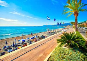 a beach with chairs and umbrellas and the ocean at Albergo Albatros in Pietra Ligure
