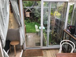 an open door to a patio with a table and chairs at Cosy hideaway with garden sauna in Cambridge in Cambridge