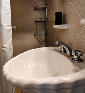 un lavandino bianco in bagno con lampada di Studios La Bella Vida en Escobar a Belén de Escobar