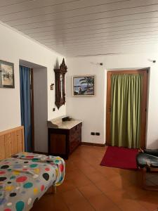 a bedroom with a bed and a dresser and a window at Dolomiti Di Brenta in Ronzone