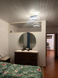um quarto com uma cama com uma cómoda e um espelho em Dolomiti Di Brenta em Ronzone