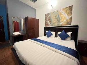 1 dormitorio con 1 cama grande con almohadas azules en Bab Al Bahrain Hotel en Manama