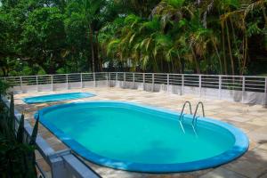 two blue swimming pools on a patio with palm trees at Pousada Murici in Barreirinhas