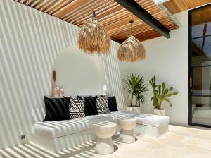 a living room with a white couch and two stools at The Suites by The Young Villas in Uluwatu